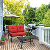 Red cushioned loveseat and coffee table set on a patio, perfect for outdoor relaxation and easy cleaning.