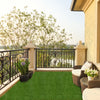 Indoor outdoor synthetic turf mat with drainage holes, featuring a natural green hue for a clean and safe play area.