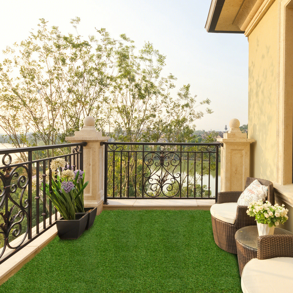 Indoor outdoor synthetic turf mat with drainage holes, featuring a natural green hue for a clean and safe play area.