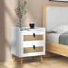 Modern bedside table with two rattan-decorated drawers and a white finish, perfect for home decor and storage.