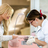Manicure nail table in pink with a bendable USB LED lamp, featuring a dust collector and soft wrist pad for comfort.