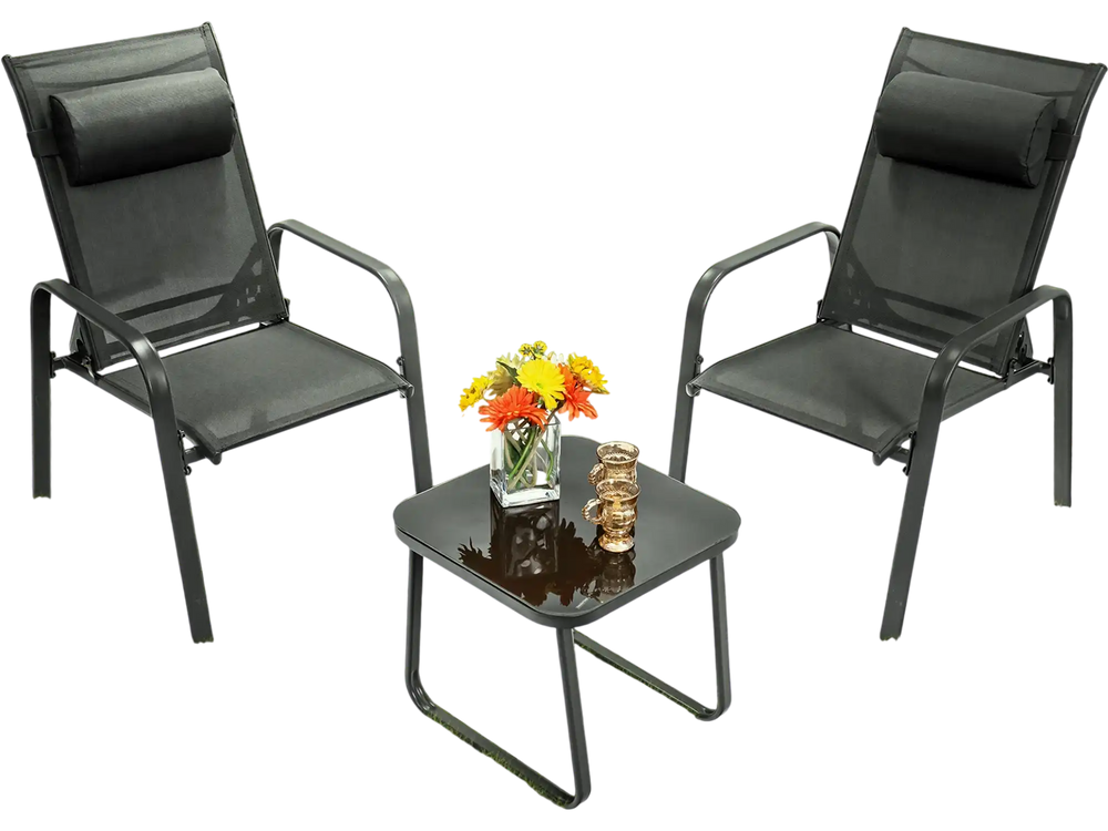 Two adjustable black chairs and a glass coffee table in a grassy outdoor setting, perfect for patio relaxation.