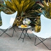 Lightweight folding patio side table with tempered glass tabletop, ideal for outdoor use in gardens or poolside.