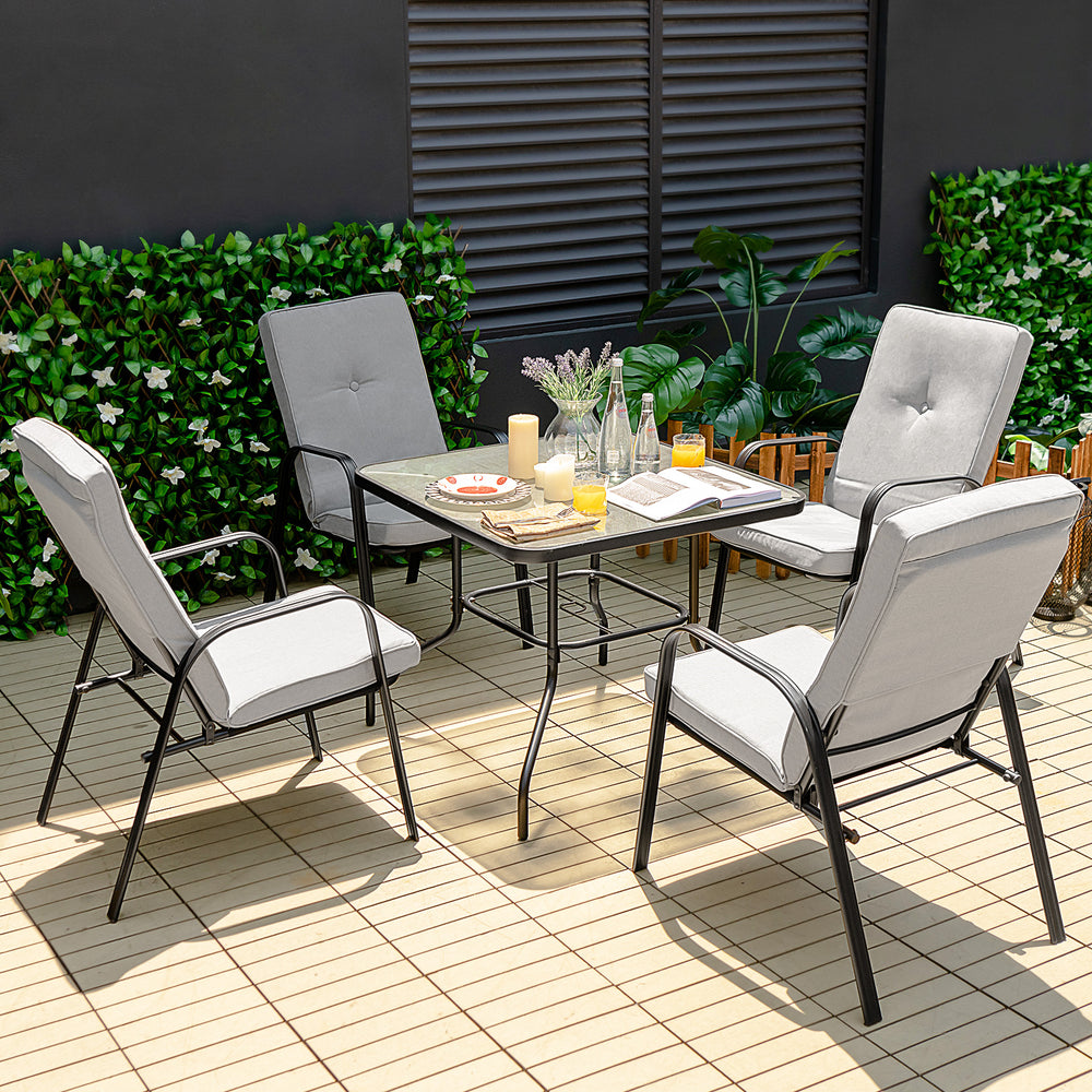 Patio dining set with stackable cushioned chairs and tempered glass tabletop, perfect for outdoor relaxation.