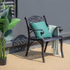 Outdoor cast aluminum chair with armrests and curved seat, featuring a green cushion, ideal for patio or garden use.