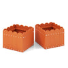 Square orange planter boxes with drainage gaps, perfect for outdoor gardens or indoor decoration, featuring a charming.