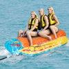 Three people enjoy riding the 3-person inflatable banana boat with EVA-padded seats and handles on the water.