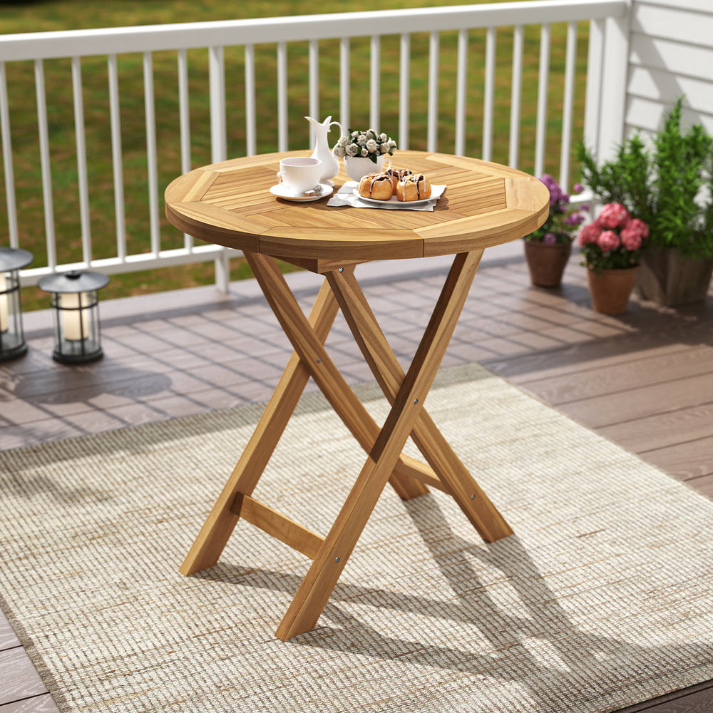Round patio teak wood dining table with slatted tabletop and X-shaped frame, perfect for outdoor dining on the balcony.