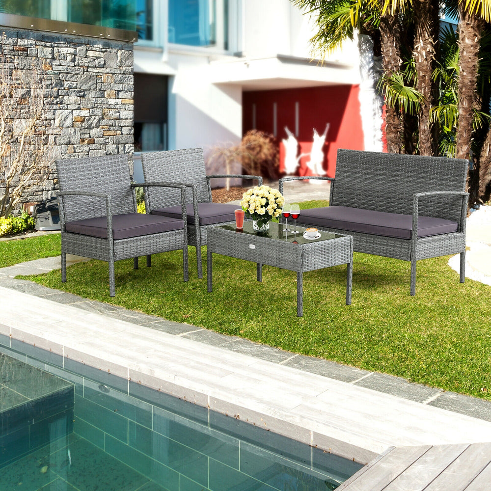 4-piece outdoor rattan conversation set with comfortable cushions, featuring a coffee table, ideal for backyard.