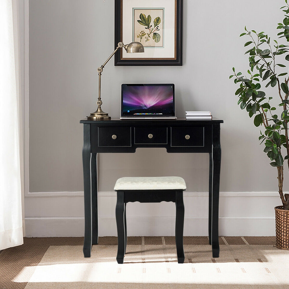 Vanity table set with 5 drawers, oval mirror, and cushioned stool in black, perfect for makeup or writing.