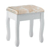 White padded stool with floral pattern, part of a makeup vanity set, providing comfort for beauty routines.