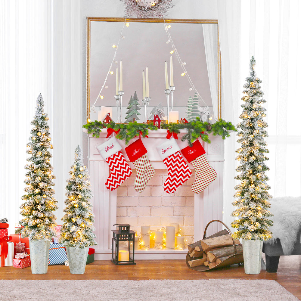 Set of 3 pre-lit snow flocked artificial Christmas trees with warm white LED lights for festive holiday decor.