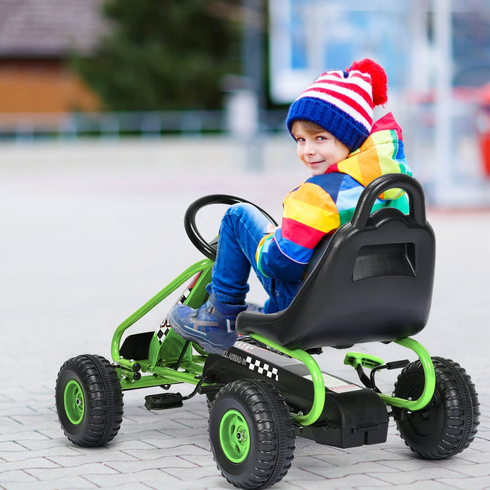 Child riding a green 4 wheel pedal powered ride-on with adjustable seat, designed for kids aged 3-6 years.