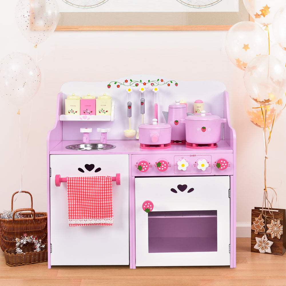 Kids wooden kitchen toy playset in pink with strawberry details, featuring a sink, stove, and ample storage for cooking.
