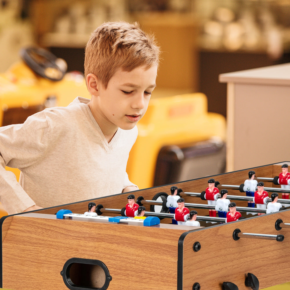 Child playing with Space Saving Table Football featuring durable handle and scoreboard for fun and competition.