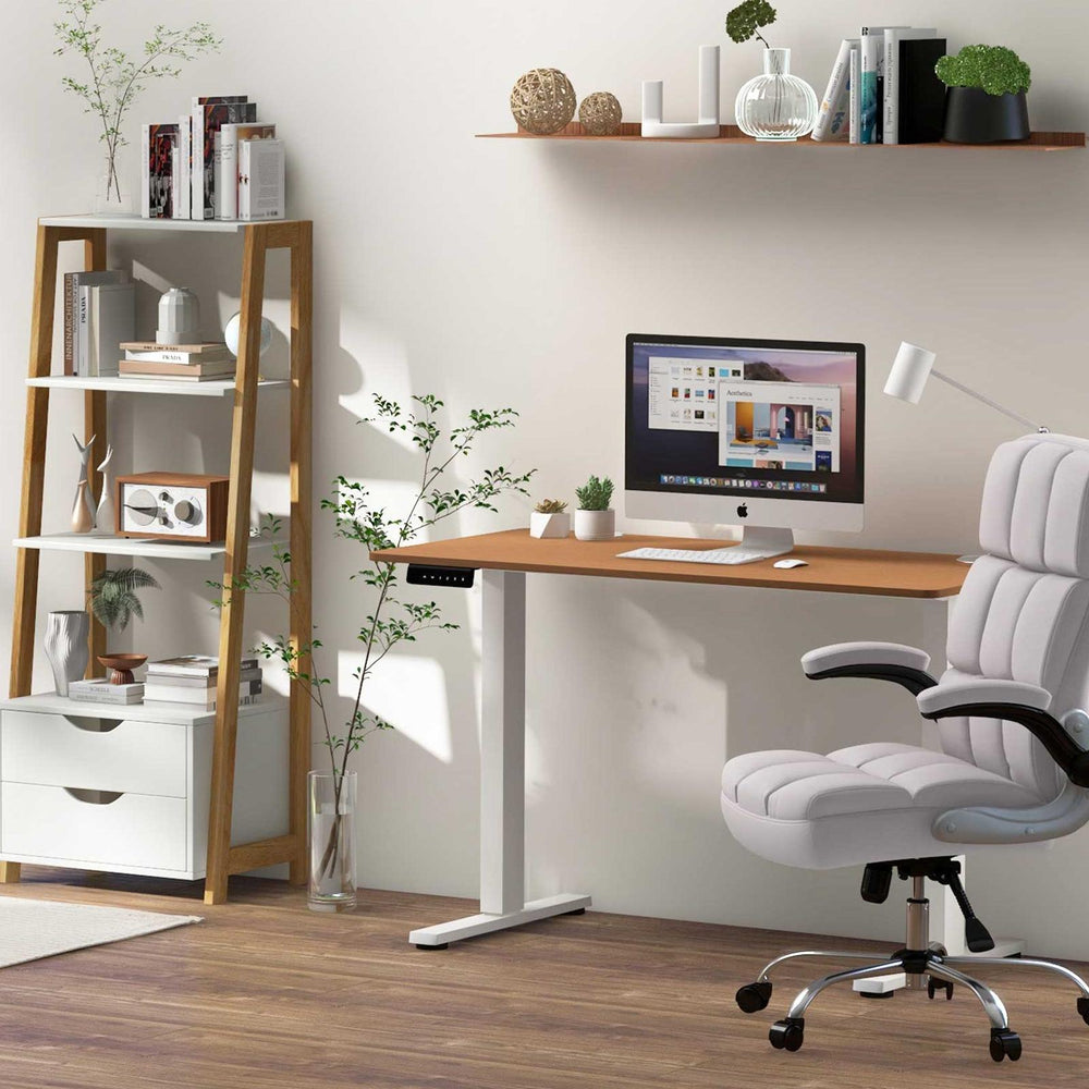 Compact standing desk with memory height settings and ergonomic high-back chair in a modern home office setup.