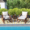 Outdoor patio furniture set featuring cushioned chairs and a glass-top table, made of PE rattan and acacia wood.
