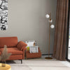 Floor lamp with three glass shades beside a rust-colored accent chair and 3-seat sofa, ideal for stylish living rooms.