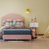 Twin pink bed with decorative pillows, blue and pink rocking chairs, and a white nightstand for a stylish children's.