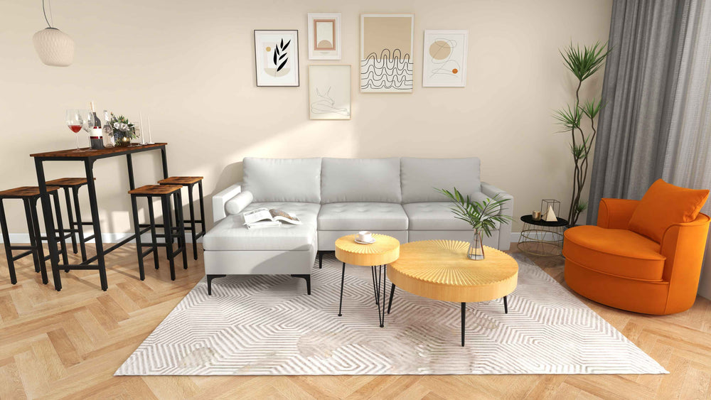 L-shaped modular sofa with steel backrest, 48-inch pub dining table, and nesting coffee tables in a modern living space.