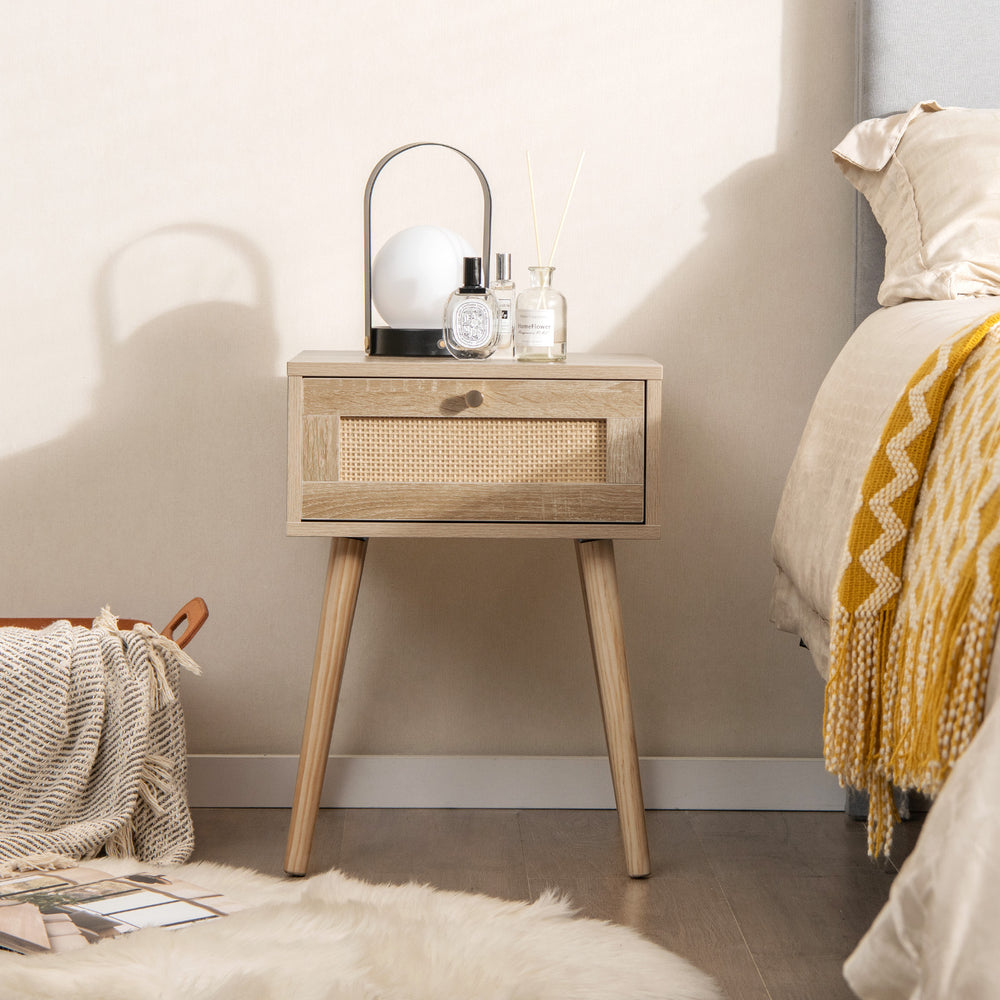 Modern rattan nightstand with drawer and solid wood legs, featuring a natural oak finish, perfect for bedroom decor.