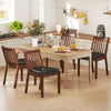 Espresso PU leather upholstered dining chairs with padded seats, arranged around a wooden dining table in a kitchen.
