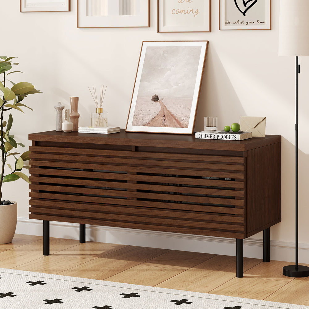 Mid Century fluted TV stand in walnut with metal legs, featuring hidden compartments for organized storage and cable.