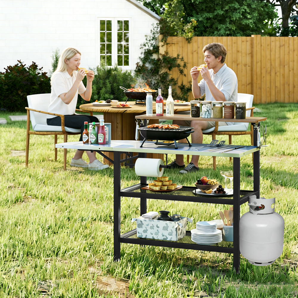 Outdoor foldable grill table with flip-up top, storage shelves, and sturdy frame, perfect for backyard grilling.