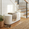 Upholstered beige ottoman bench with oval shape and corduroy surface, perfect for entryway or living room use.