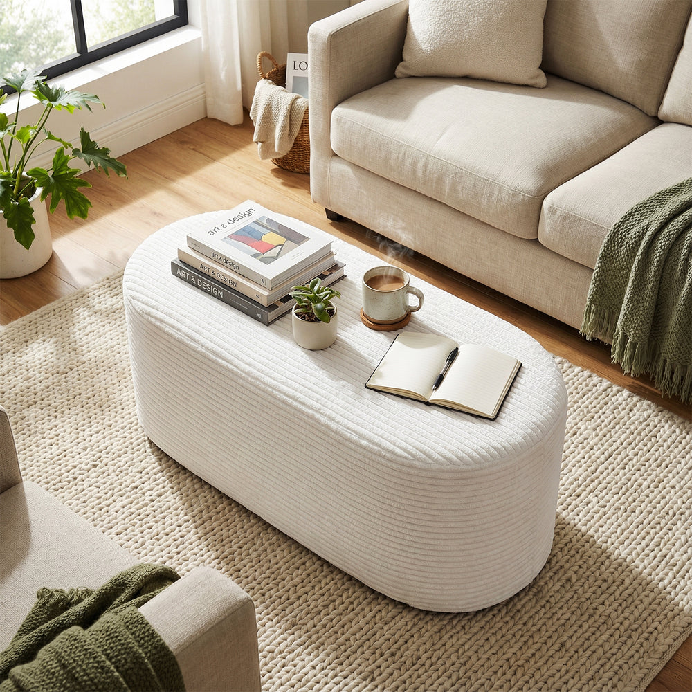 Beige upholstered ottoman bench with a soft corduroy finish, ideal for stylish accent in living room or hallway.