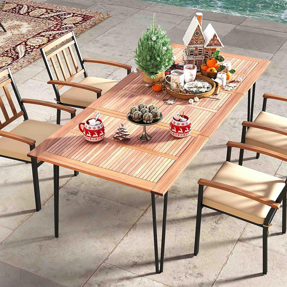 Outdoor dining table with acacia wood top and four ergonomic chairs, perfect for backyard gatherings.
