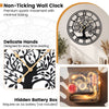 Large 27-inch black metal wall clock with tree of life design, featuring delicate hands and non-ticking quartz movement.