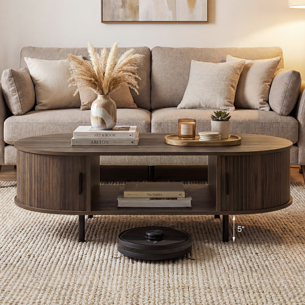 Oval coffee table with walnut finish, featuring dual side shelves and fluted door accents for a stylish living room.