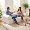 Convertible folding sofa bed in beige with removable armrests, plush corduroy cover, perfect for lounging or sitting.