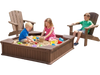 Kids playing in a sandbox with cover, surrounded by two kid-sized Adirondack chairs for outdoor fun and relaxation.