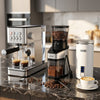 Conical burr grinder with 60 grind settings enhances coffee flavor, complementing the espresso machine and milk frother.