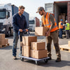 Folding platform hand truck with collapsible bed, 4 wheels, and robust metal frame for easy moving in warehouses.