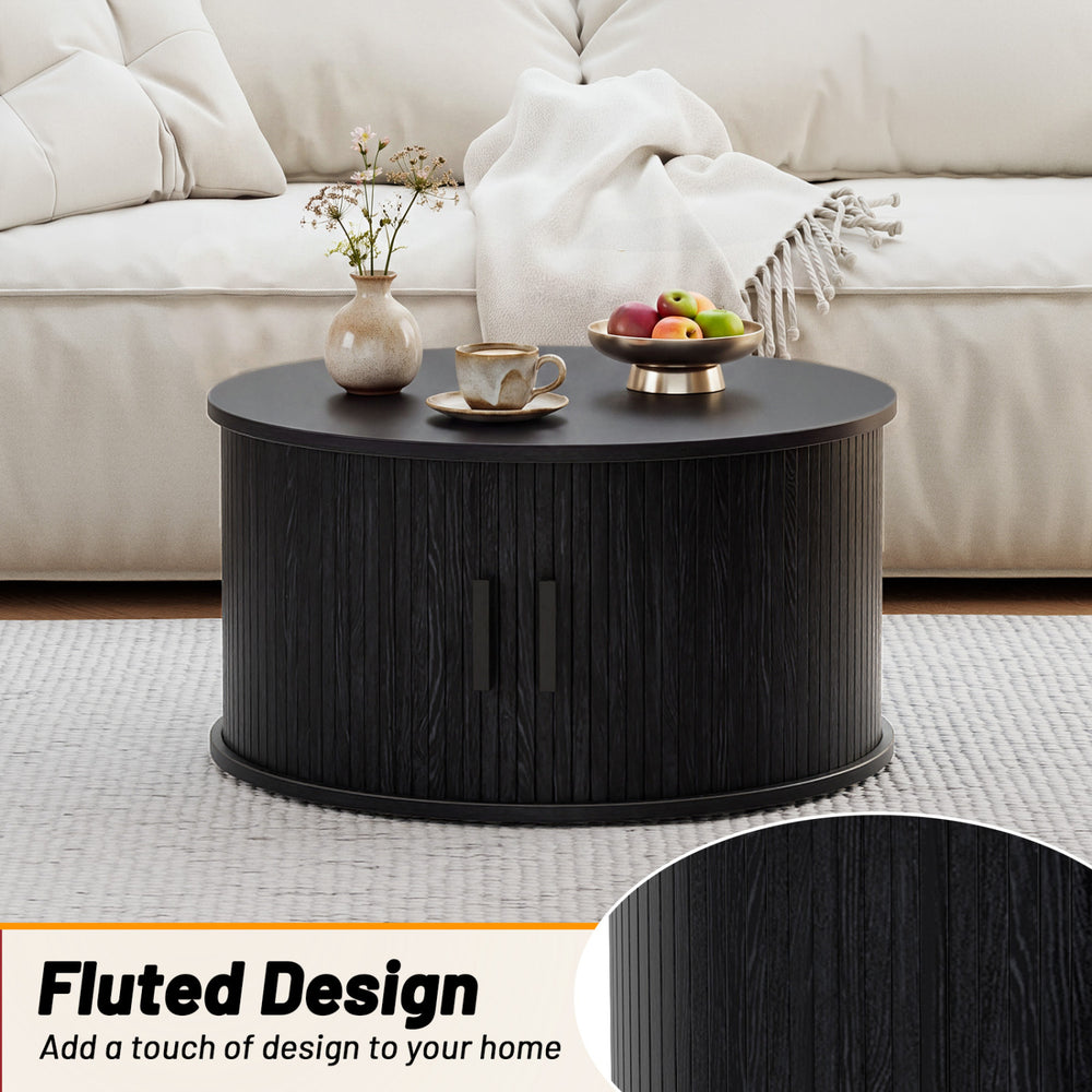 Round black coffee table with fluted design, sliding tambour door, and spacious storage for living room organization.