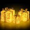 Three lighted gift boxes with bows, featuring warm white LEDs, perfect for enhancing holiday living room decor.