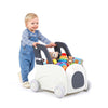 Toddler pushes a 4-in-1 baby car toy box with wheels, featuring a flip-up seat and storage for toys.