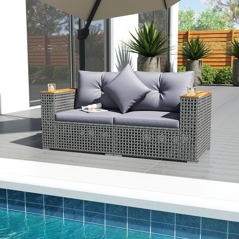 Grey 5-piece outdoor rattan sofa set with cushioned loveseat and coffee table, perfect for poolside relaxation.
