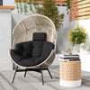 Wicker oversized egg style chair with black cushions and headrest, perfect for backyard or living room relaxation.