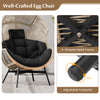 Oversized black wicker egg chair with ergonomic design, thick cushions, and adjustable footpads for versatile comfort.